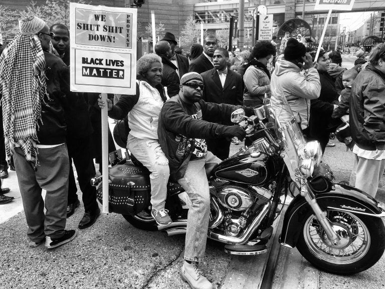 A protester on a motorcycle beside a Black Lives Matter sign in Baltimore, April 25, 2015